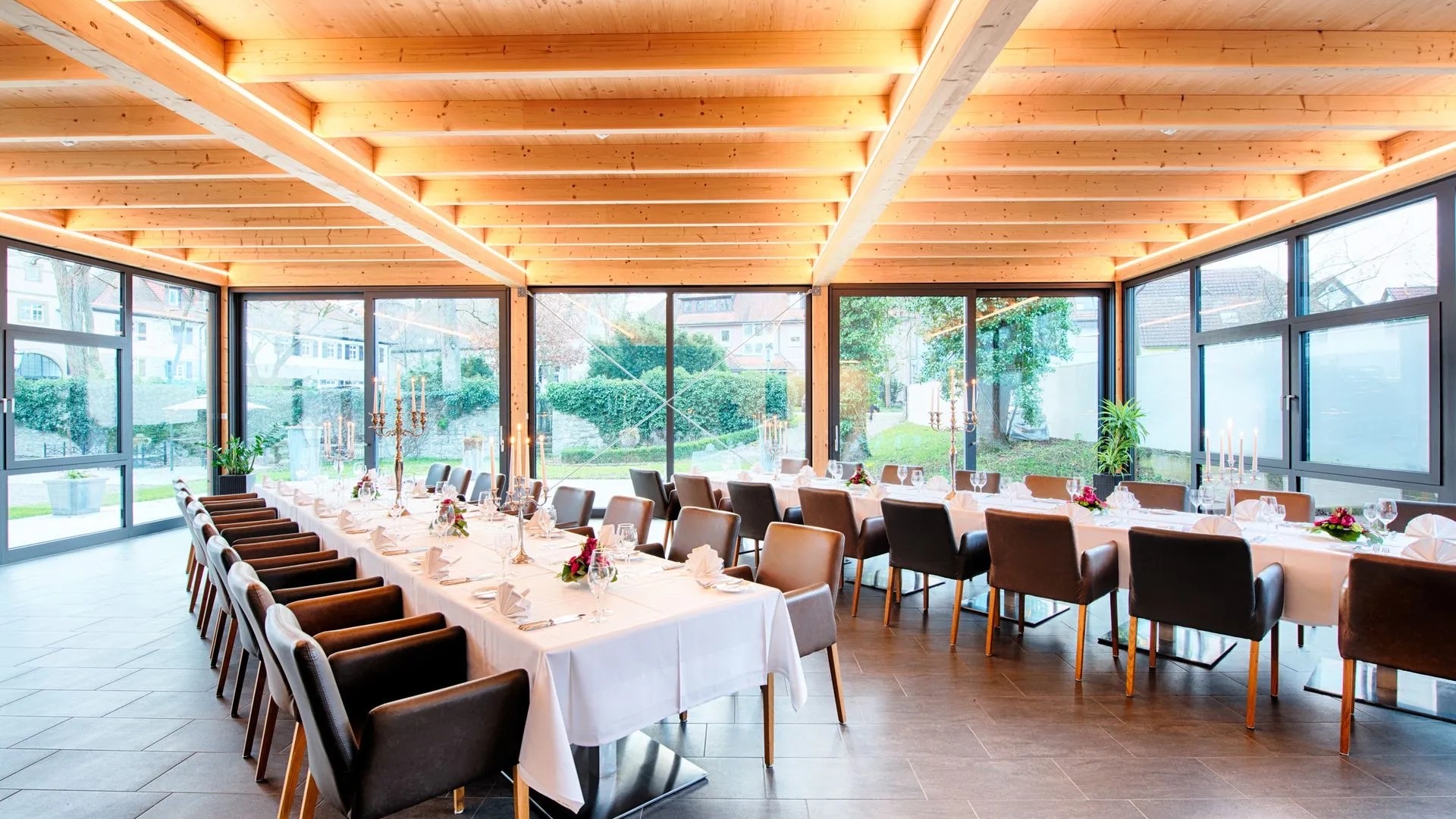 Festlich eingedeckte Tafel im Wintergarten mit Blick in den Schlossgarten