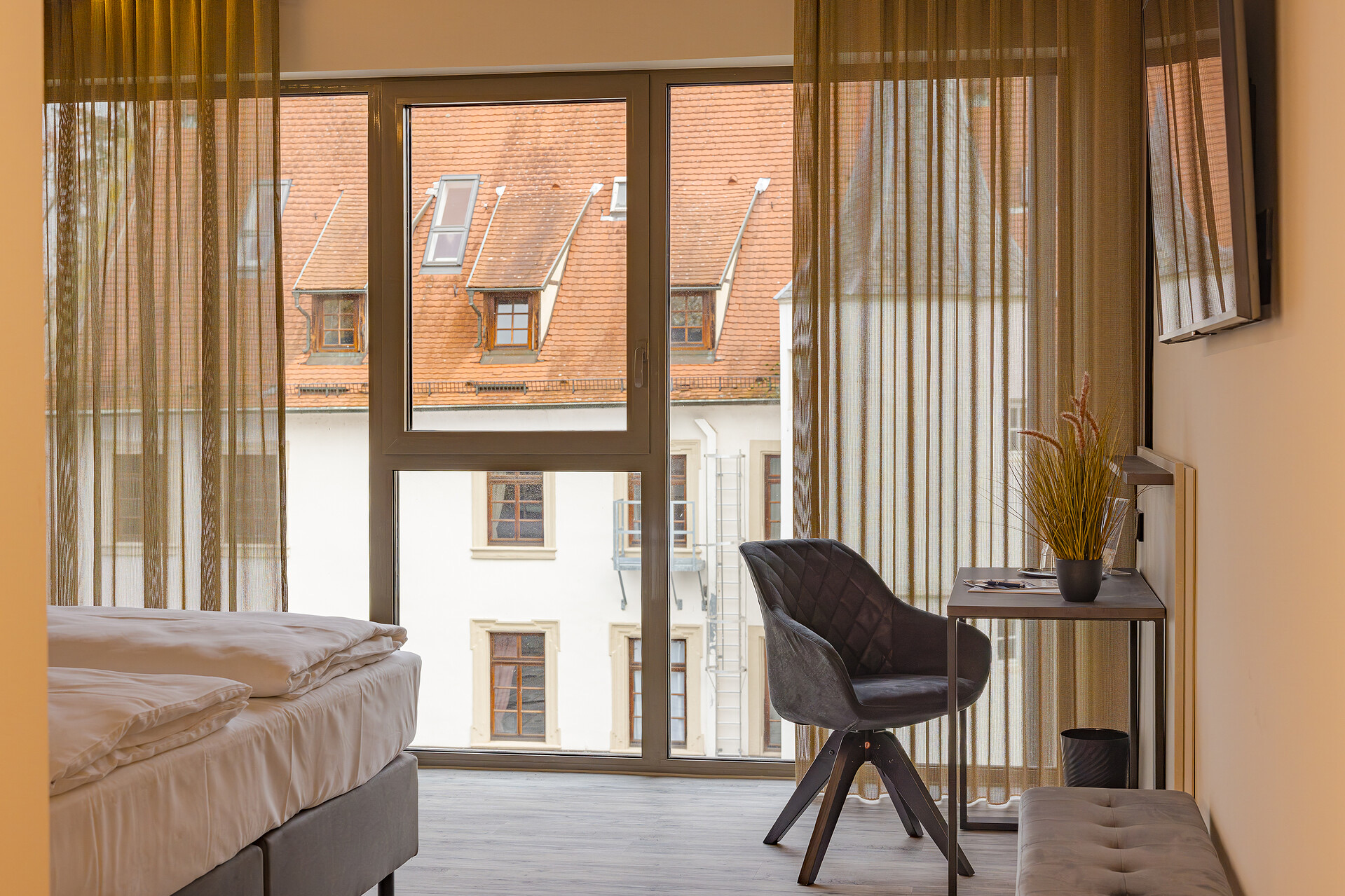 Großzügig geschnittenes Neubauzimmer mit raumhoher Fensterfront und Schreibtisch